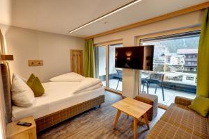 um quarto de hotel com uma cama e uma grande janela em Der Siegeler B&B - this lifestylehotel rocks em Mayrhofen