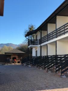 a building with black railings and a patio at Guest House AltaRio in Khamyshki
