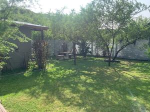 un patio con árboles y un banco y una valla en Brisas Del Uruguay en Colón