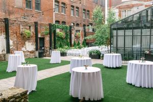 a group of white tables with flowers on the grass at Hotel Covington Cincinnati Riverfront in Covington