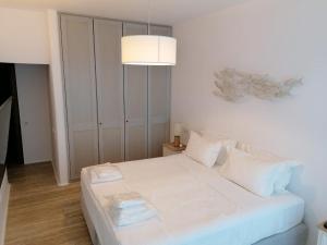 un letto bianco in una stanza con lampada di AGL Luxury Villas a Mykonos Città