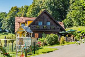 ein Haus mit einem Spielplatz davor in der Unterkunft Weingut & Buschenschank Pölzl in Großklein