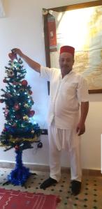 um homem ao lado de uma árvore de Natal em Riad Simon em Marrakech