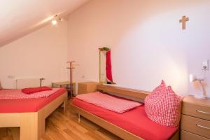 two beds in a room with a cross on the wall at Ferienhof Sauter Romanshorn in Neukirch