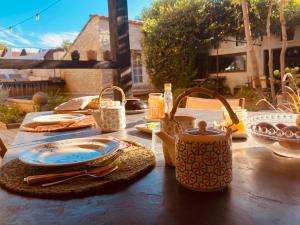 een tafel met een theepot en borden erop bij M&S - Maison FÉRAUD in Saint-Rémy-de-Provence