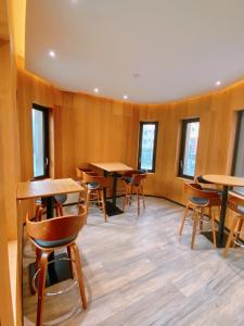 una stanza con tavoli, sedie e finestre di LE LE Motel a Città di Pingtung