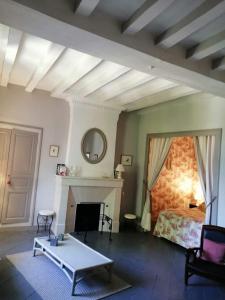 ein Wohnzimmer mit einem Bett und einem Tisch in der Unterkunft Le Clos de Ligré in Ligré