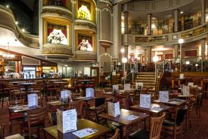 a restaurant with wooden tables and chairs in a room at Nautical Apartment by Seaside Llandudno in Llandudno