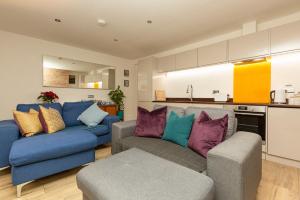 a living room with two couches and a kitchen at SoHot Stays Stylish & Cosy with Hot Tub & Log Burner, Margate in Margate
