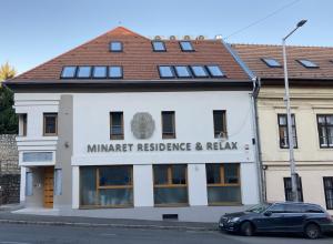 a building with a car parked in front of it at Minaret Residence & Relax Pécs in Pécs