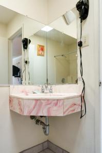 a bathroom sink with a large mirror on the wall at Mission Motel in Lynwood