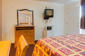una camera con letto, cassettiera e TV di Mission Motel a Lynwood