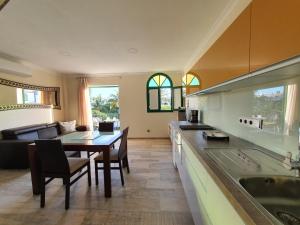 プエルト・デ・モガンにあるAPARTAMENTO SUNSET PUERTO DE MOGANのキッチンとテーブルとソファのあるリビングルーム
