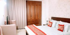 a bedroom with a bed with red and white pillows at 2BHK Short Stay Apartment walking Max Saket ( LIFT +Kitchen+Parking+3 nights min stay) in New Delhi