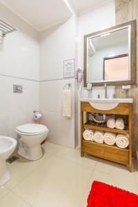 uma casa de banho com um lavatório, um WC e um espelho. em Hotel Calimera em Santa Teresita