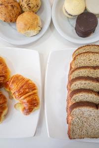 a table with three plates of bread and pastries at Hotel Calimera in Santa Teresita