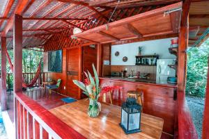 a porch of a house with a table and a kitchen at Casitas Las Flores in Puerto Viejo