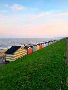 a row of colorful beach huts on the beach at Gorgeous Gorleston holiday home in Gorleston-on-Sea