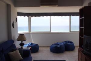 uma sala de estar com sacos de feijão azul em frente a uma janela em Panoramic Beach View Apartment (T2) in Caparica em Costa da Caparica