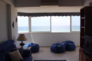 a living room with blue bean bags in front of a window at Panoramic Beach View Apartment (T2) in Caparica in Costa da Caparica