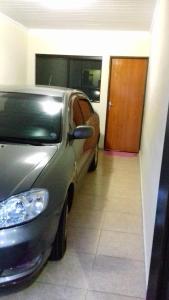 une voiture en argent garée dans un garage avec une porte dans l'établissement Casa Central, à Olímpia