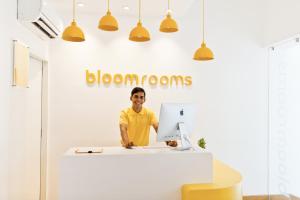 班加羅爾的住宿－bloomrooms @ City Centre，站在桌子上,手提电脑的人