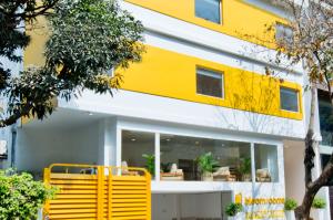 un banco amarillo frente a un edificio en bloomrooms @ City Centre, en Bangalore