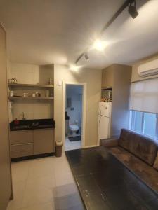 a kitchen with a couch and a sink and a refrigerator at Lindo apto, 100metros da praia, na Av Brasil com a Av Central melhor localização in Balneário Camboriú