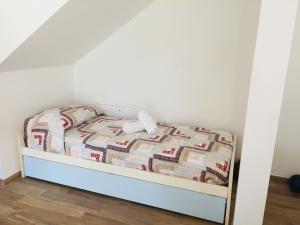un piccolo letto in una stanza con pareti bianche di B&B I Falchi Pellegrini a Monzuno