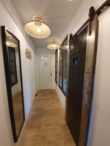 a hallway with a door and a mirror and lights at Il Etait Une Fois in Pierrefonds