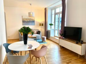 een woonkamer met een tafel en een televisie bij Residence Rybna 9- Old Town in Praag
