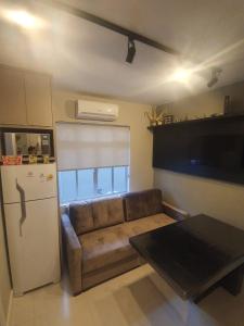 a living room with a couch and a refrigerator at Lindo apto, 100metros da praia, na Av Brasil com a Av Central melhor localização in Balneário Camboriú