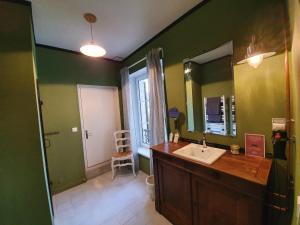 a bathroom with a sink and a mirror at Il Etait Une Fois in Pierrefonds