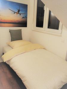 two beds in a room with a picture of an airplane at Sroom Stuttgart Flughafen Messe in Leinfelden-Echterdingen