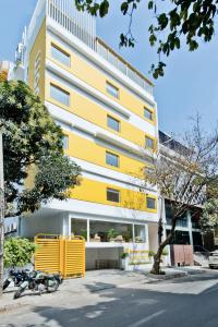 a yellow and white building with bikes parked in front of it at bloomrooms @ City Centre in Bangalore