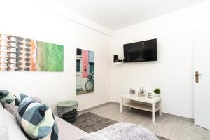 un soggiorno bianco con un divano e una TV di TOMÁS HOME a Nazaré