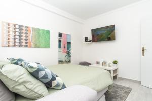 una stanza bianca con un letto e un divano di TOMÁS HOME a Nazaré