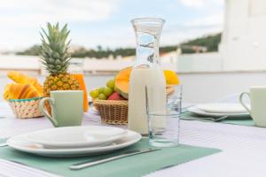 a table with a bottle of milk and a plate of fruit at TOMÁS HOME in Nazaré