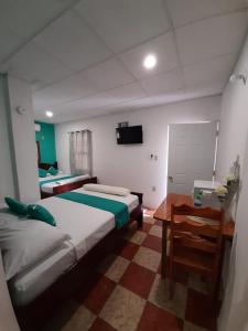 um quarto com 2 camas, uma secretária e uma televisão em SAINT Charles Inn, Belize Central America em Punta Gorda