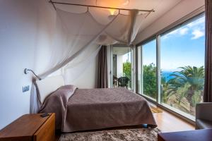 Un dormitorio con una cama y una ventana grande. en Casa Martinhos by LovelyStay, en Caniço 45 fotos más