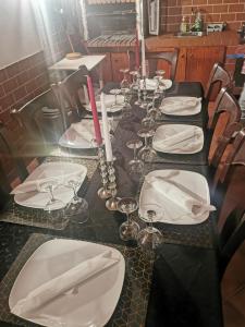 a long table with white plates and candles on it at Férias Inesquecíveis in Carregado +33 photos