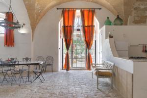 uma sala de jantar com cortinas cor de laranja e uma mesa e cadeiras em Masseria Tornesella Don Giuliano em Parabita