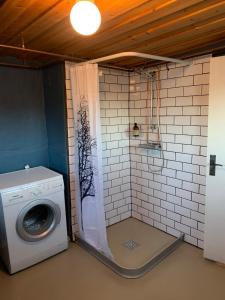 una lavatrice in un bagno con doccia di Mysigt rum med privatbadrum a Västra Fors
