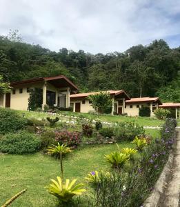 a house with a garden in front of it at Arenal Roca Suites in Fortuna