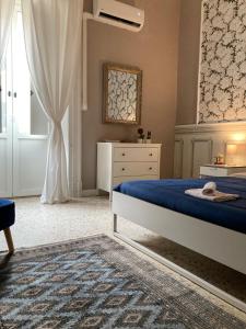 una camera con un letto blu e una finestra di Casa- Corso Umberto a Taranto