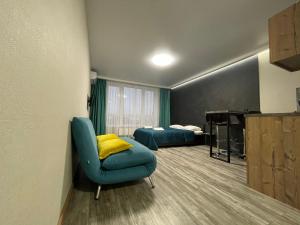 Habitación con 2 camas, silla y piano en Solo Apartment Kamenskaya en Kiev