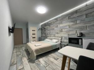 1 dormitorio con cama y pared de piedra en Solo Apartment Kamenskaya en Kiev