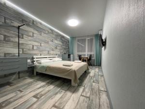 基輔的住宿－Solo Apartment Kamenskaya，一间卧室设有一张床和石墙