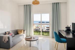 a living room with a couch and a view of the ocean at Apartamentos Islamar Arrecife in Arrecife