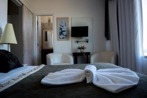 a hotel room with a bed with towels on it at Atlântico Hotel in Rio das Ostras